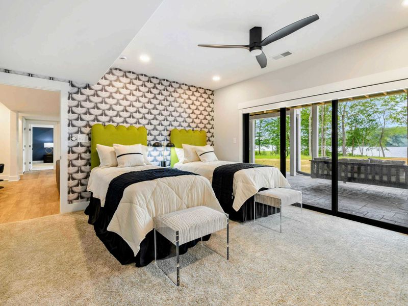 Bedroom 3 - Two queen beds with bold green headboards and geometric wallpaper sit beside sliding doors to the lakefront patio.