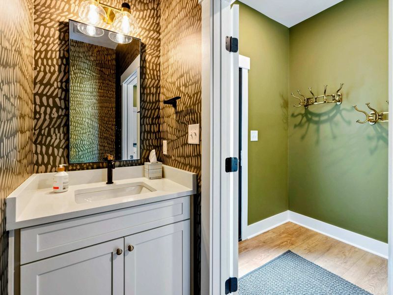 Powder Room - Bold animal-print wallpaper and a gray vanity with gold fixtures make a stylish statement off the main level.