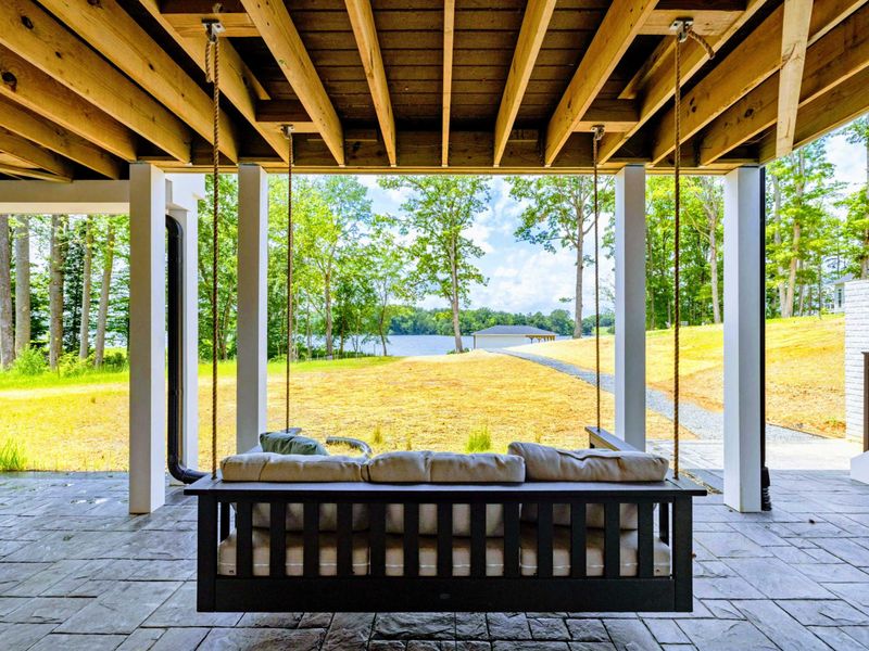 Deck - A swing daybed offers a gentle place to sit close, talk softly, and watch the lake beyond the trees.