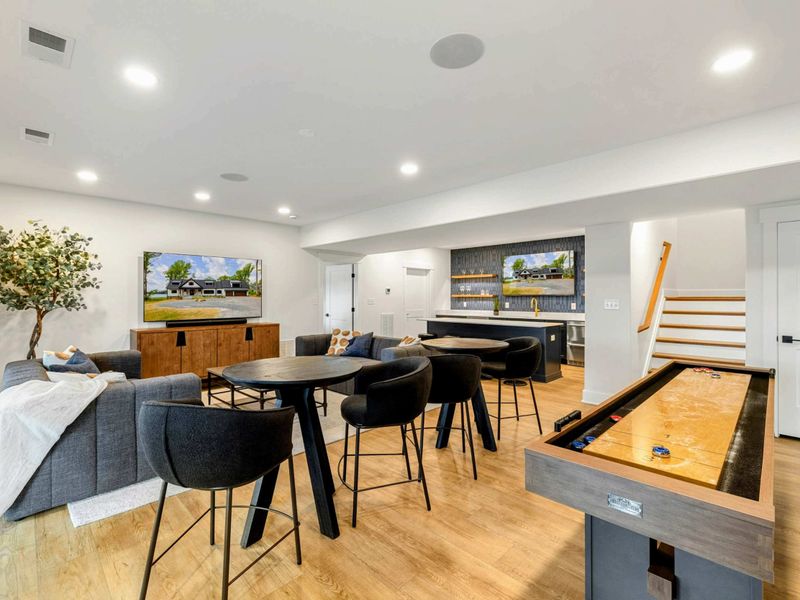 Game Room Lounge - A pub-height table, deep sectional sofas, and a large TV sit next to the wet bar for easy entertaining.