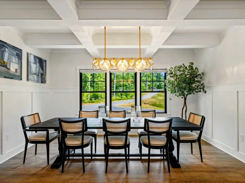 Dining Room - A dark wood table seats eight beneath a gold bubble chandelier and coffered beam ceiling.