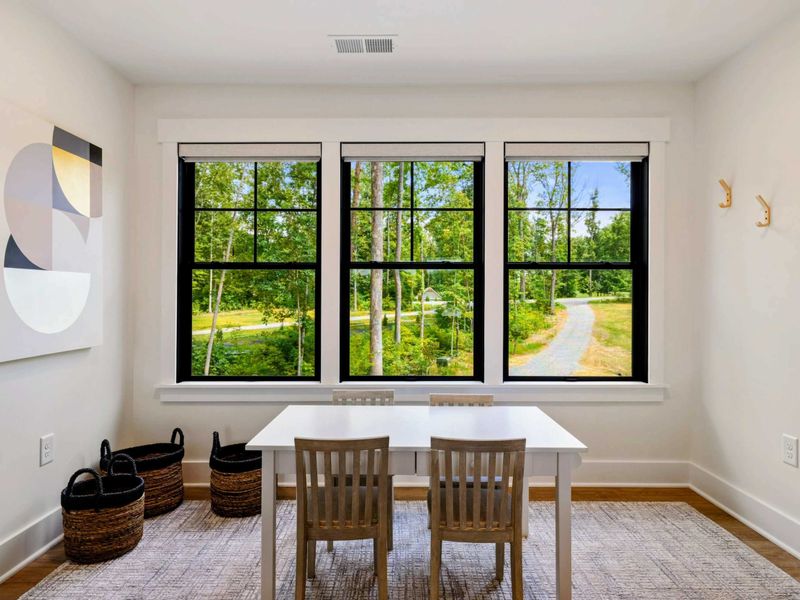 Craft Room - A small table, chairs, and storage baskets sit by three windows overlooking the yard, perfect for kids' projects.