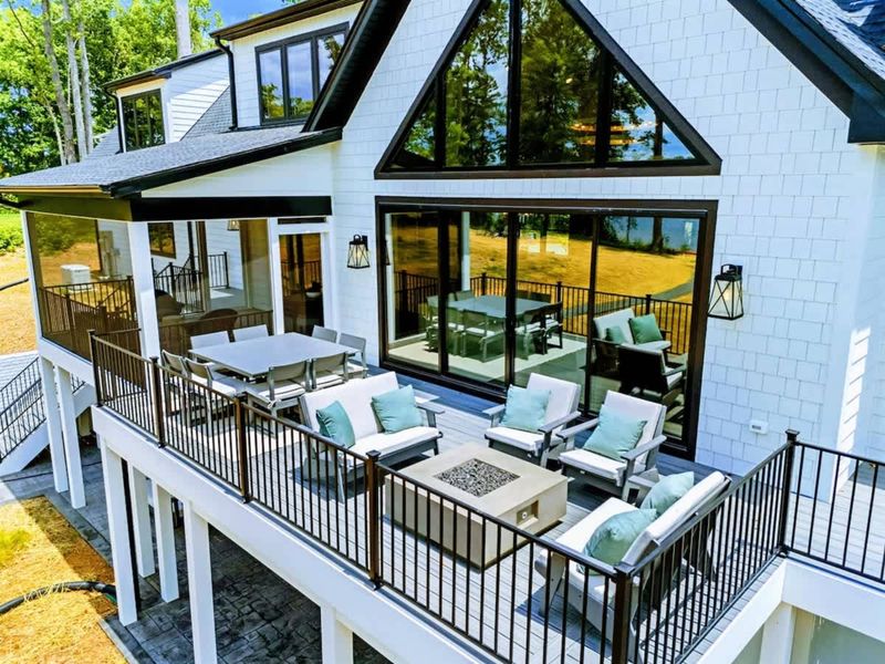 Terrace Living, Elevated – A refined outdoor lounge framed by soaring glass and modern lakehouse design.
