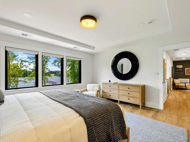 Bedroom 4 - A tray ceiling, four-panel mirror over the dresser, and warm wood tones bring a polished feel to this king suite.