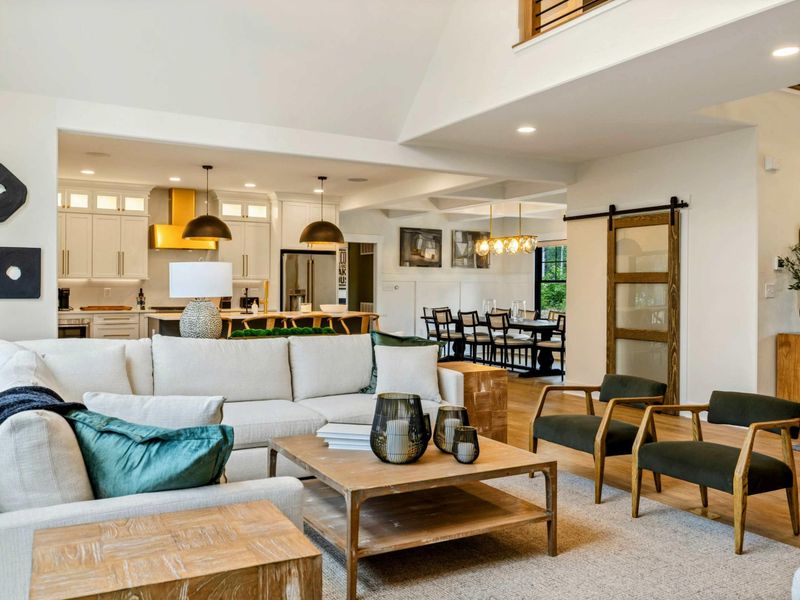 Great Room - A cream sectional, accent chairs, and natural wood coffee table anchor the open-concept main level.