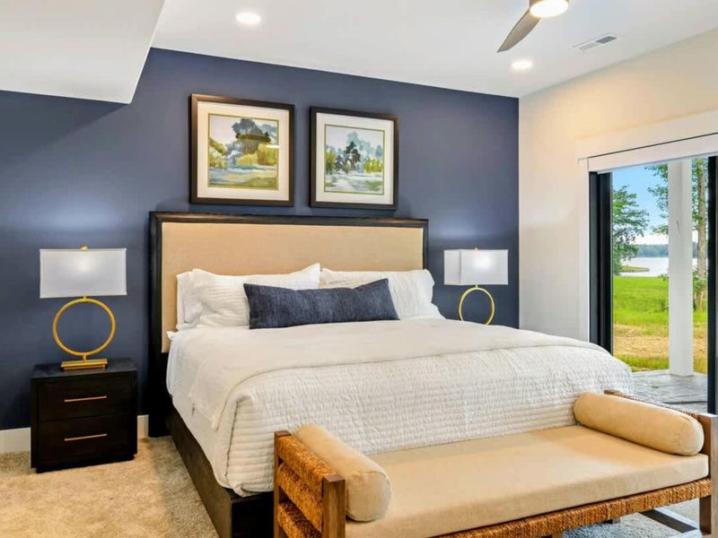 Bedroom 2 - Landscape paintings and a bench at the foot of the bed complement the lake views through the sliding doors.