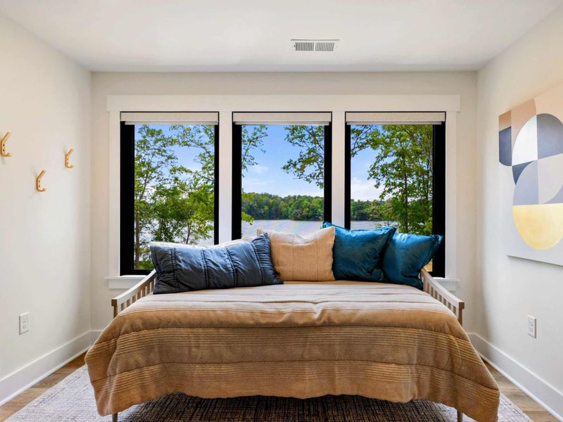 Daybed Nook - A cozy single bed tucked beside four windows overlooking the lake, ideal for reading or an afternoon nap.