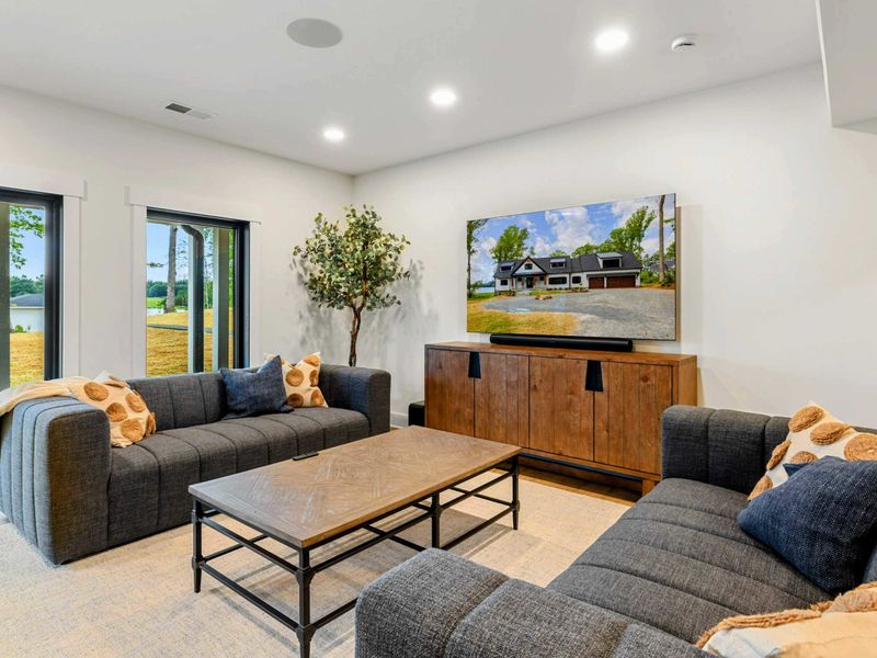 Game Room Lounge - Sliding glass doors bring in lake views and natural light alongside the TV lounge and wet bar.