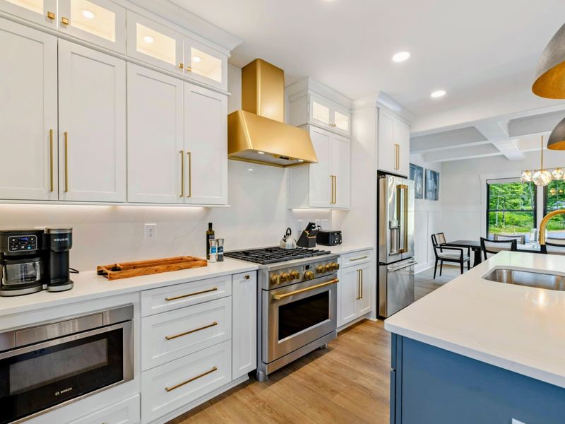 Kitchen - A stainless steel refrigerator with built-in water dispenser and gold-accented cabinetry complete the chef's kitchen.