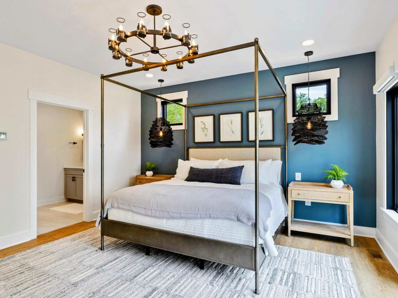 Primary Suite - The spacious layout includes a gold canopy bed, en-suite bathroom access, and windows overlooking the lake.