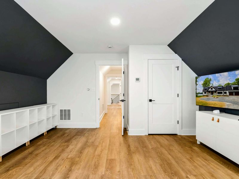 Bunk Room Loft - Built-in cubbies and a large TV on a white console anchor the media area of this versatile upper-level space.