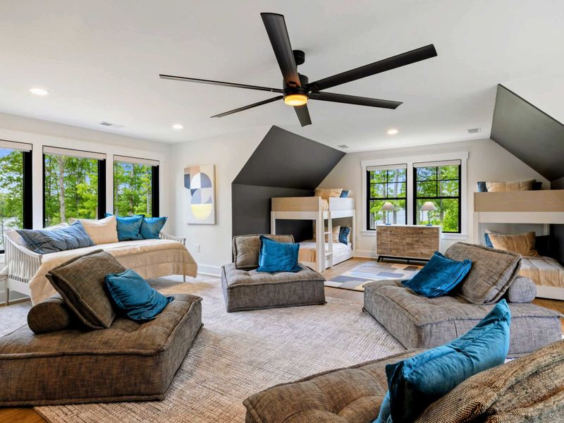 Bunk Room Loft - Two sets of built-in bunks flank the central lounge area, with teal pillows and windows on every side.