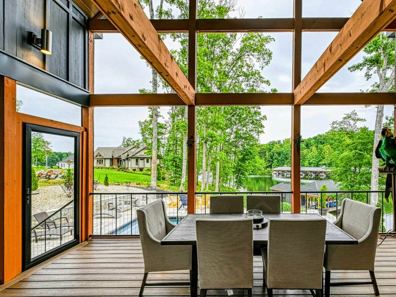 Screened Porch View - Looking through the A-frame screened wall past the dining table to the landscaped grounds and lake beyond.