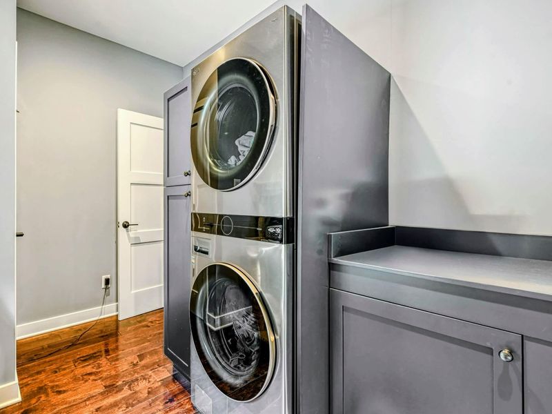 Laundry Room - A stacked washer and dryer with a folding counter in a convenient laundry space with hardwood floors.