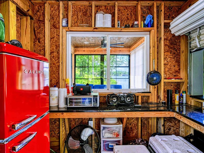 Dock Kitchenette - A retro red mini fridge, coffee maker, and countertop cooking station inside the boathouse provide a self-contained lakeside setup.