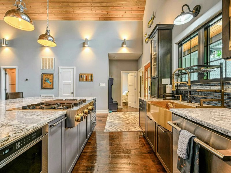 Kitchen Overview - The full gourmet kitchen with copper sink, granite island, dark cabinetry, and the two-story A-frame ceiling soaring above.