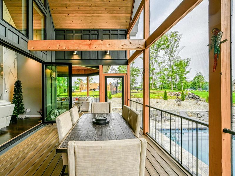 Screened Porch Overview - The screened porch connects seamlessly to the indoor living spaces, with sightlines through to the marble fireplace.