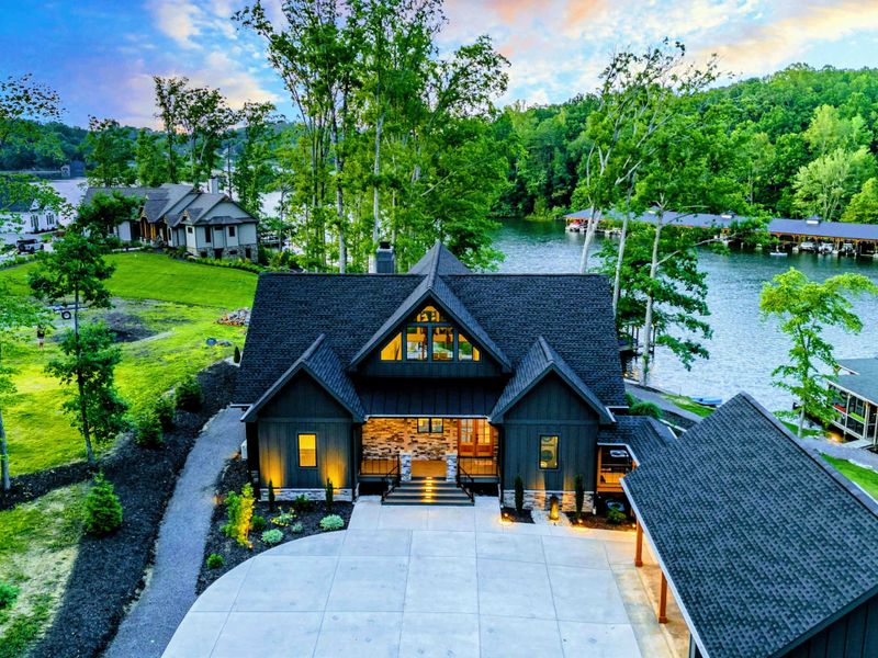 Aerial Twilight - From above, the home, dock, boathouse, and surrounding cove create a stunning lakefront estate scene at sunset.