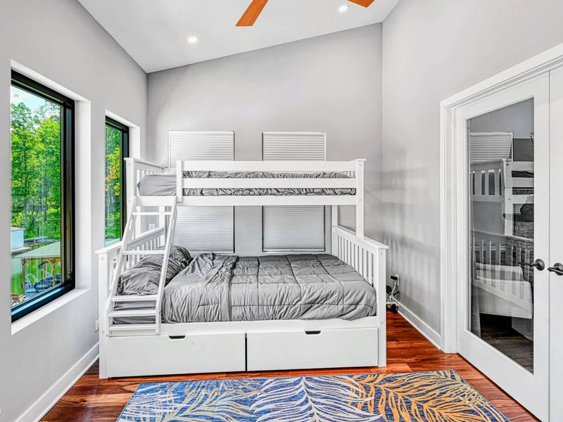 Bunk Room - Another angle of the twin-over-full bunk bed with mirrored closet doors, a tropical area rug, and panoramic lake views.