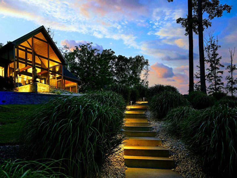 Illuminated Path - The stepped pathway glows with embedded lighting as it winds through the ornamental grass gardens toward the A-frame glass wall.