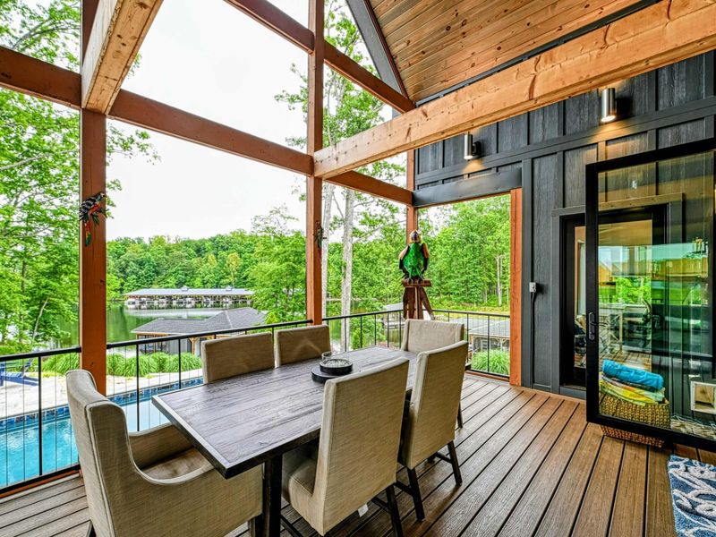 Screened Porch - Another angle of the screened porch dining area, with the A-frame timbers rising above and views of the pool, trees, and lake.