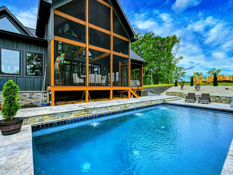 Pool and Exterior - Another angle of the pool and home showing the full rear facade, screened porch, and manicured landscaping.