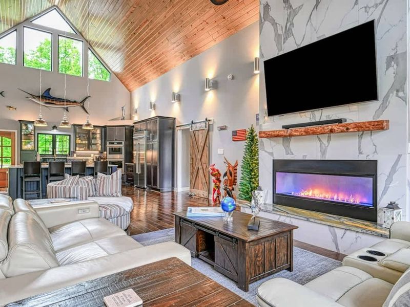 Great Room to Kitchen - The open floor plan flows from the living room past the A-frame peak windows to the gourmet kitchen and fish-themed pendant lights.