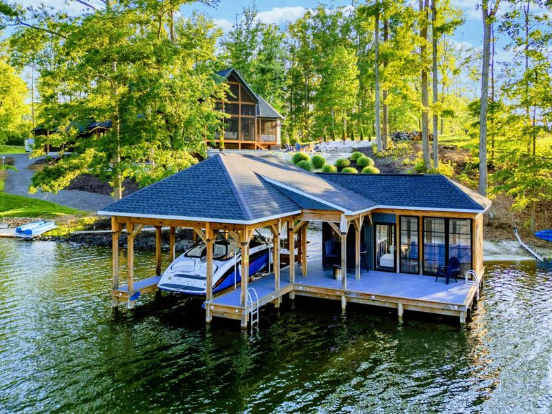 Aerial Boathouse - A closer aerial view of the boathouse structure showing the screened lounge, bar area, and boat slip nestled in the cove.