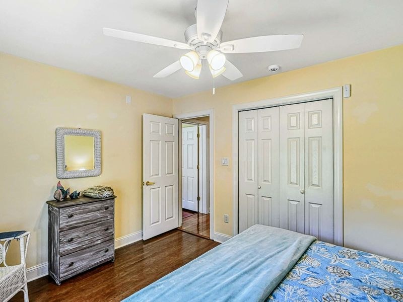 Bedroom 4 - Alternate view showing the closet, weathered coastal dresser, and rope-frame mirror.