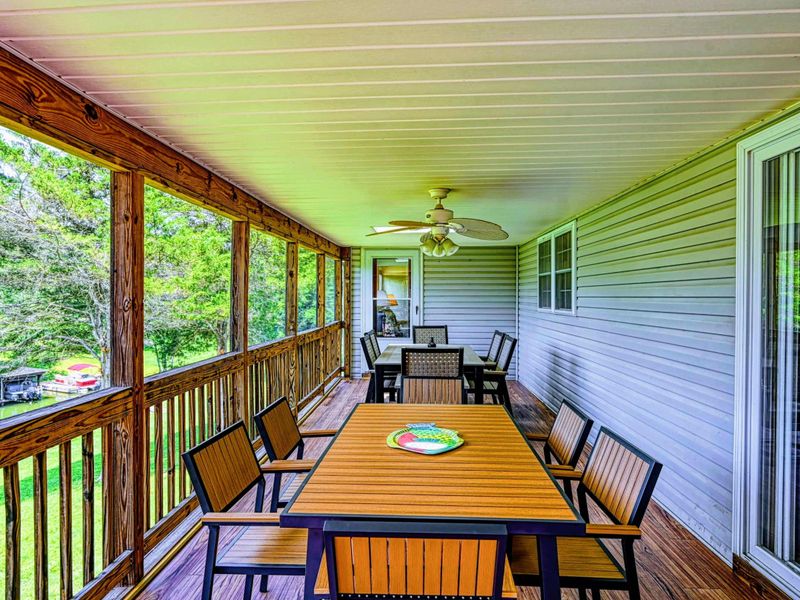 Screened Porch - Alternate view of the dining table with ceiling fan and sightlines through to the yard and deck.