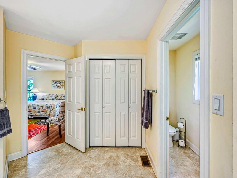 Primary Suite - Hallway connecting the bedroom to the en suite bathroom with closet and tile flooring.