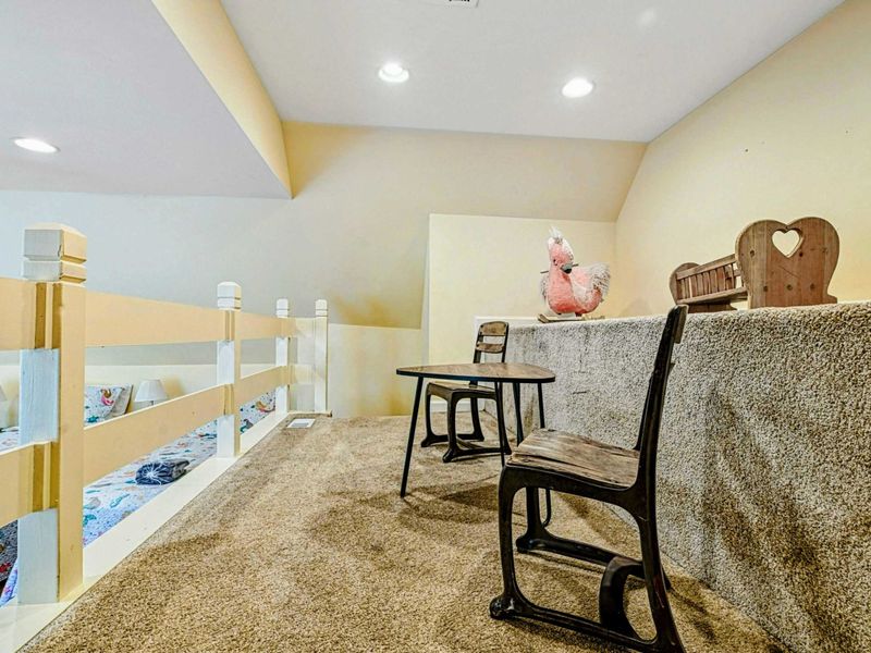 Loft Play Area - Carpeted area above the bunk room with a kid-sized table and chairs for little ones.