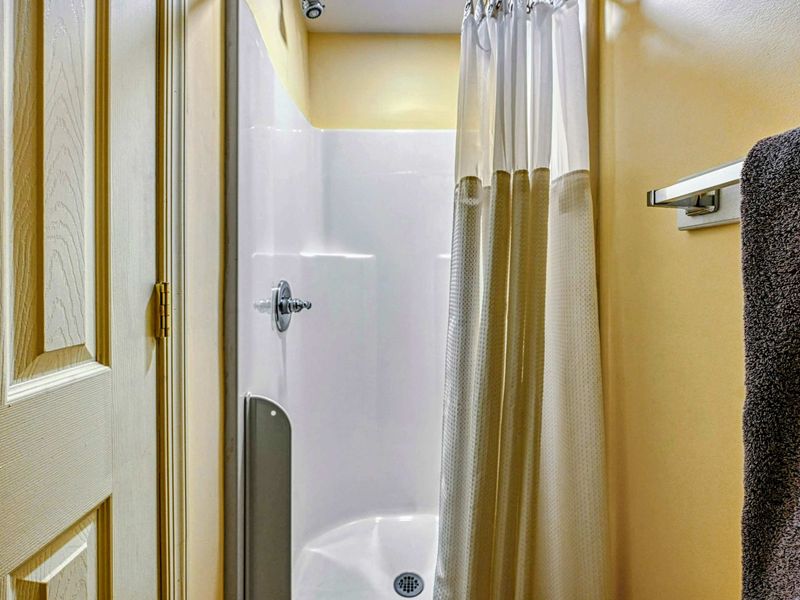 Upper Bathroom - Stand-up shower stall with curtain for quick rinses on the upper level.