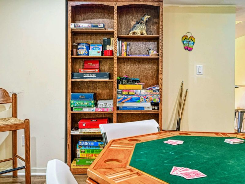 Game Room - Close-up of the bookshelf stocked with board games, puzzles, and cards for rainy-day entertainment.