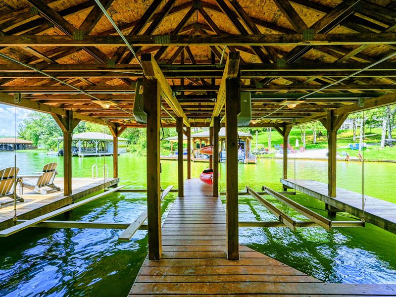 Dock - Covered boat slips with a center walkway opening to the lake and neighboring cove.