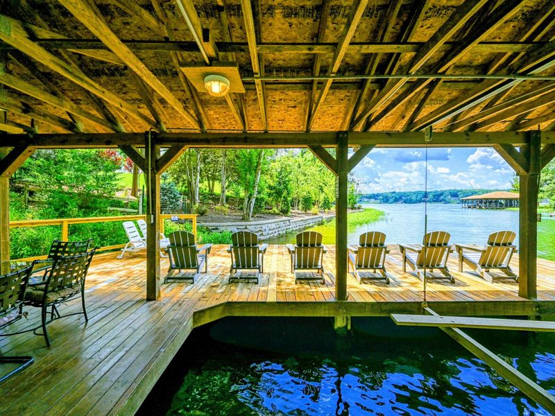 Dock - Interior view looking out at the Adirondack chairs and open water from the covered boat slip.