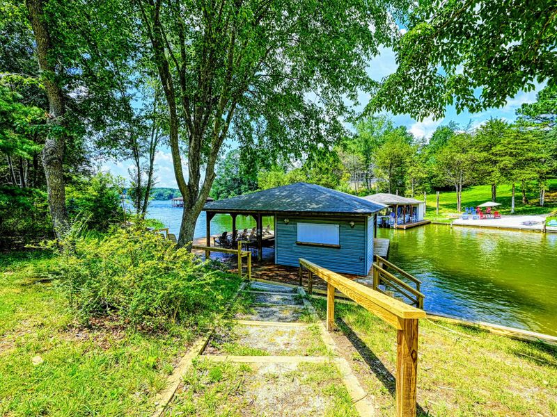 Yard - Walkway leading down through the trees to the dock and boathouse at the water.