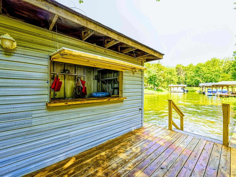 Dock - Storage shed exterior with life vests hanging in the window and dock access to the water.