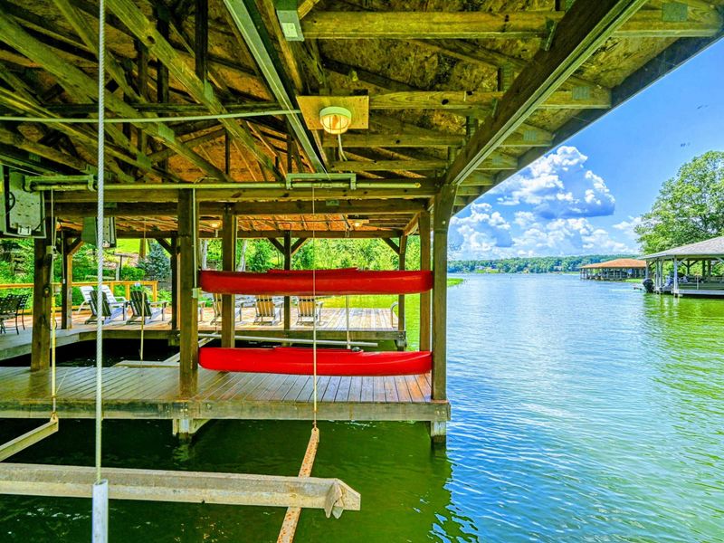 Dock - Red kayak and canoe stored in the covered dock with open views to the lake beyond.