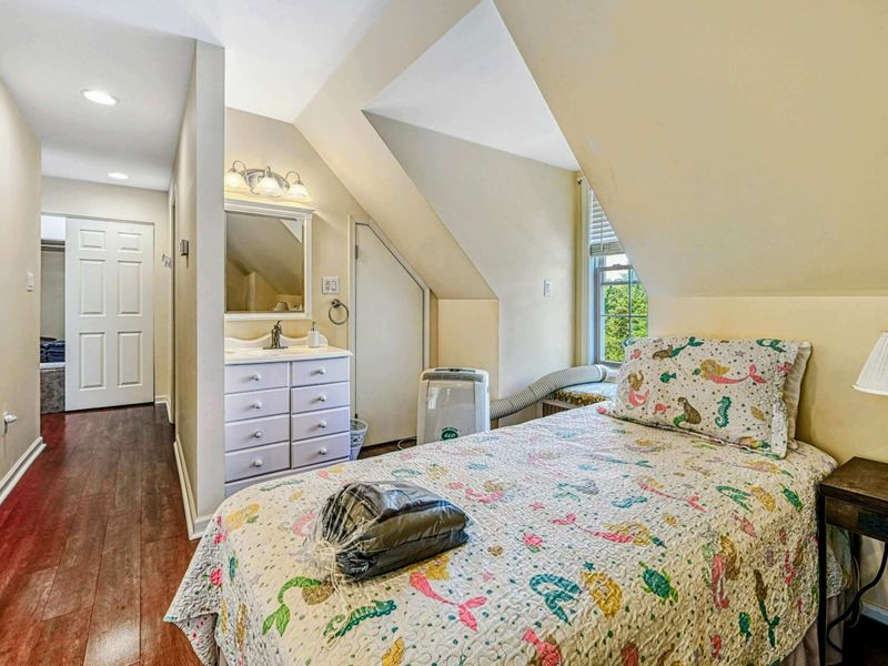 Upper Level Bedroom - Twin bed with sea creature quilt, built-in vanity and sink, and dormer window nook.