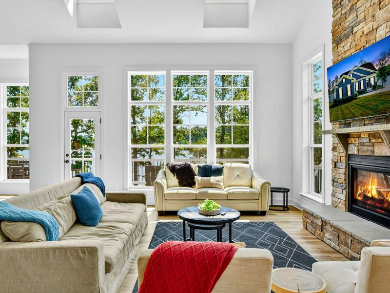 Great Room - Two-story ceilings, a floor-to-ceiling stone fireplace, gas fire, and a Smart TV anchor the heart of the home.