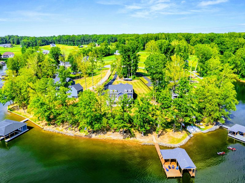 Aerial Waterfront - A drone view of The Shoreline's wooded lot, private dock, and quiet stretch of Lake Anna shoreline.