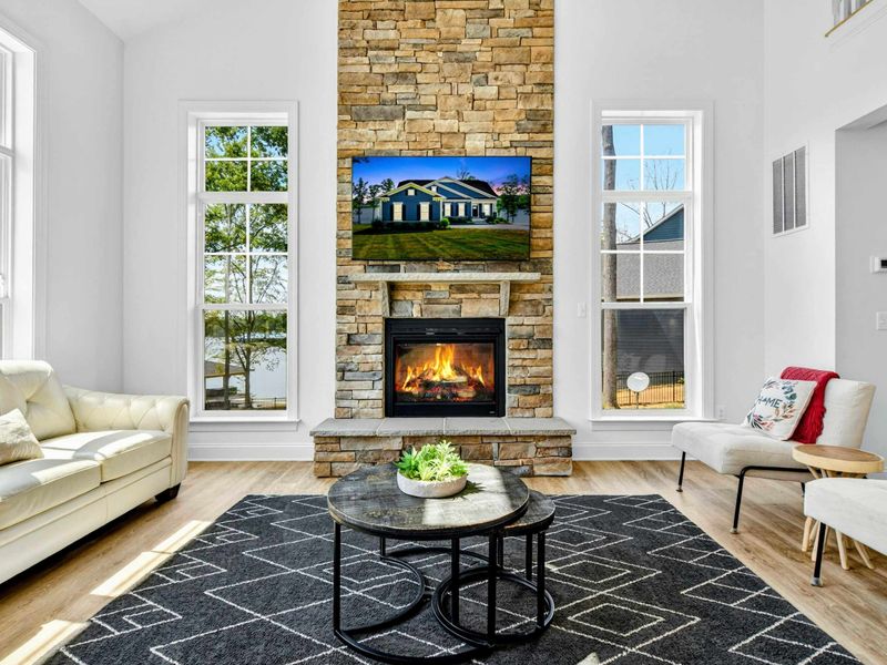 Stone Fireplace - A gas fire glows in the natural stone fireplace, with windows on either side framing the lake views.