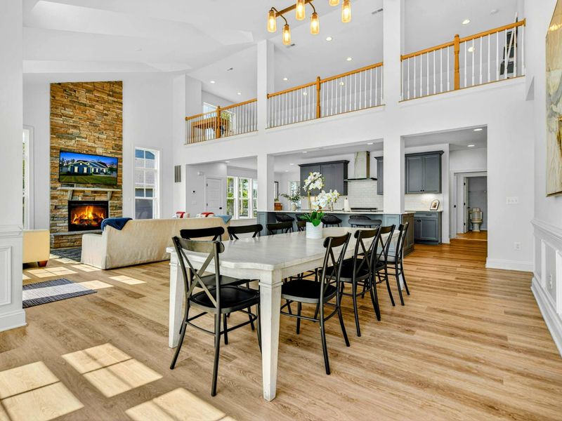 Open Living - The dining area, great room, and kitchen flow as one space, all anchored by the floor-to-ceiling stone fireplace.