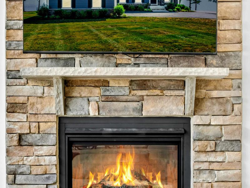 Fireplace Detail - Stacked stone climbs to the vaulted ceiling, with a Smart TV and a warm gas fire for cool nights in.