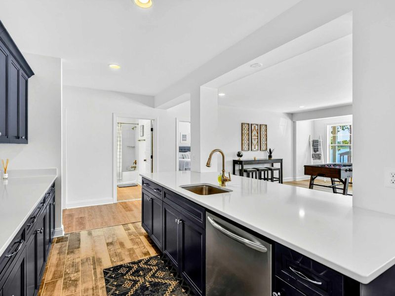 Kitchenette - A wider view of the lower-level kitchenette with island, sink, and a pass-through to the game room.