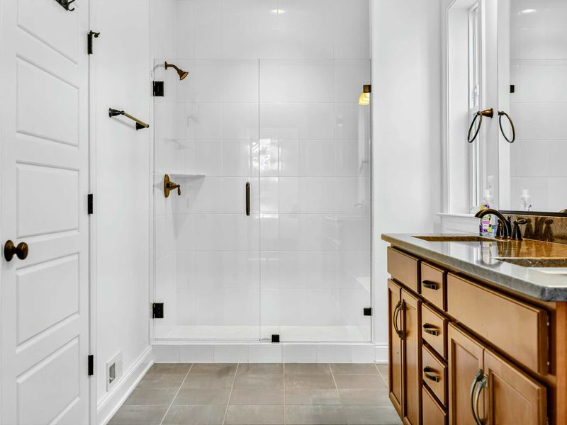 Walk-in Shower - Spacious glass-enclosed shower with white tile walls and brass fixtures for a polished finish.
