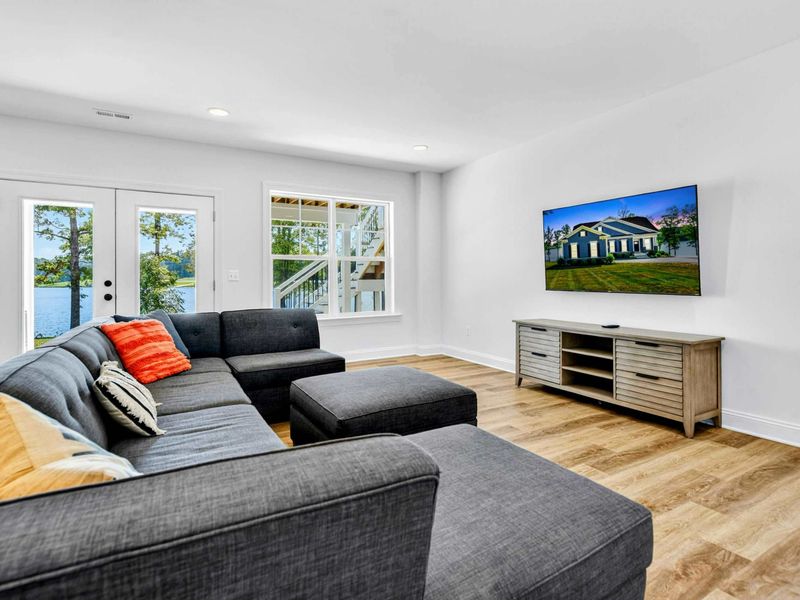 Lower Level Living - A charcoal sectional, Smart TV, and French doors out to the covered porch make this the easy-evening hangout.