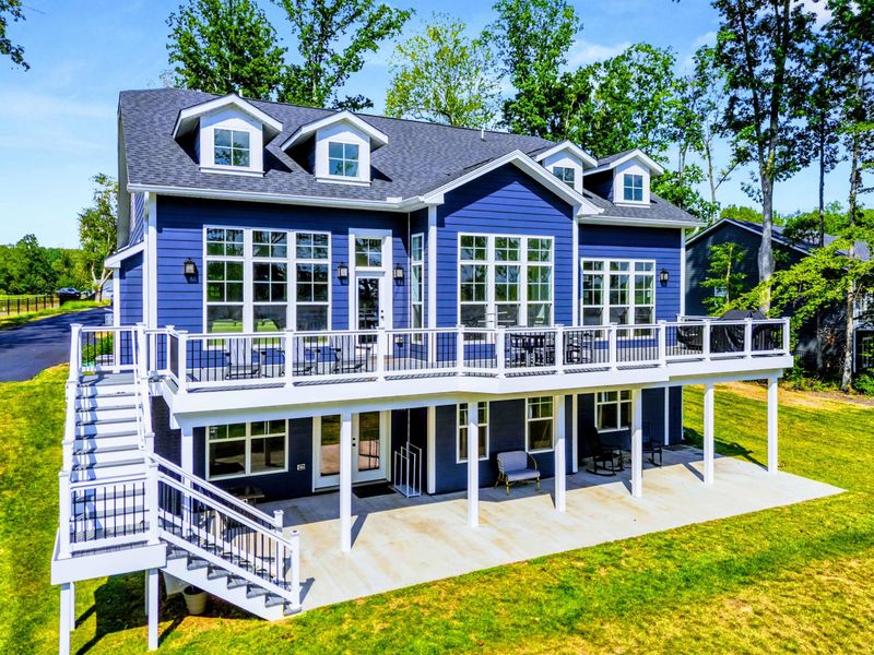 Drone View - The full home from above, with tiered Trex decks, a covered lower porch, and the lake just steps from the back door.
