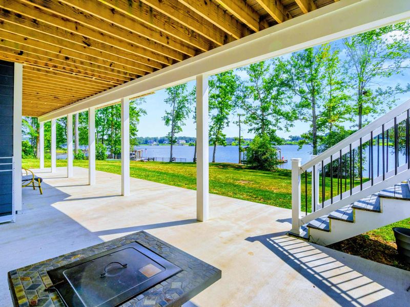 Porch & Grill - Steps from the lawn, the covered porch features a built-in grill station with the lake just beyond the railing.